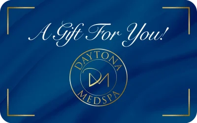 A blue gift card featuring the text 'A Gift For You!' and the logo of Daytona MedSpa.